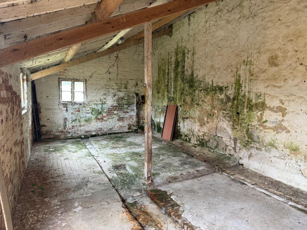 Lot: 49 - TWO FREEHOLD BARNS WITH CONSENT FOR RESIDENTIAL CONVERSION - The rear barn shown from the doorway